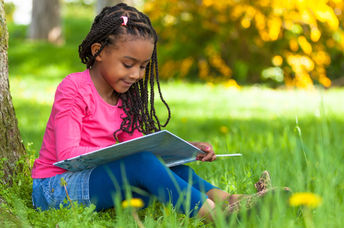 年轻的女孩在外面读书。