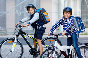 两个男孩骑自行车去学校。
