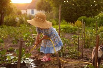 一个戴着草帽的小女孩是菜园。