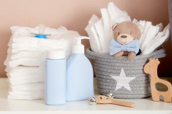 一堆尿布，玩具和婴儿配件在更换桌上。