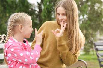 一个女人和她的女儿一起使用ASL签名。