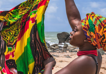 一位西非妇女拿着五颜六色的布料。