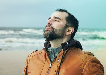 一个男人在沙滩上做深呼吸。