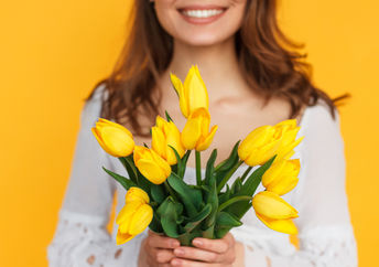 幸福的女人手拿鲜花的照片来说明善良
