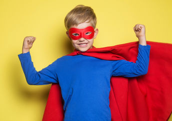 一个小男孩穿着一件超级英雄面具和角弯曲他的肌肉和感觉强烈。