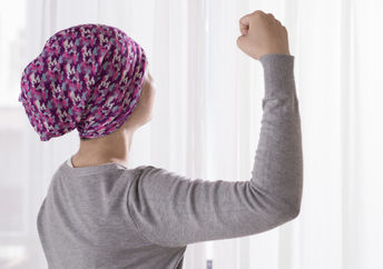 一位癌症患者胜利地举起手臂，表现出积极的态度。