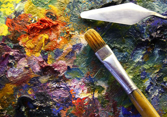 艺术家的调色板，上面有五颜六色的油漆，调色板刀和刷子。