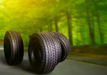 夏季，在森林道路上的汽车轮胎在背景中有树木。