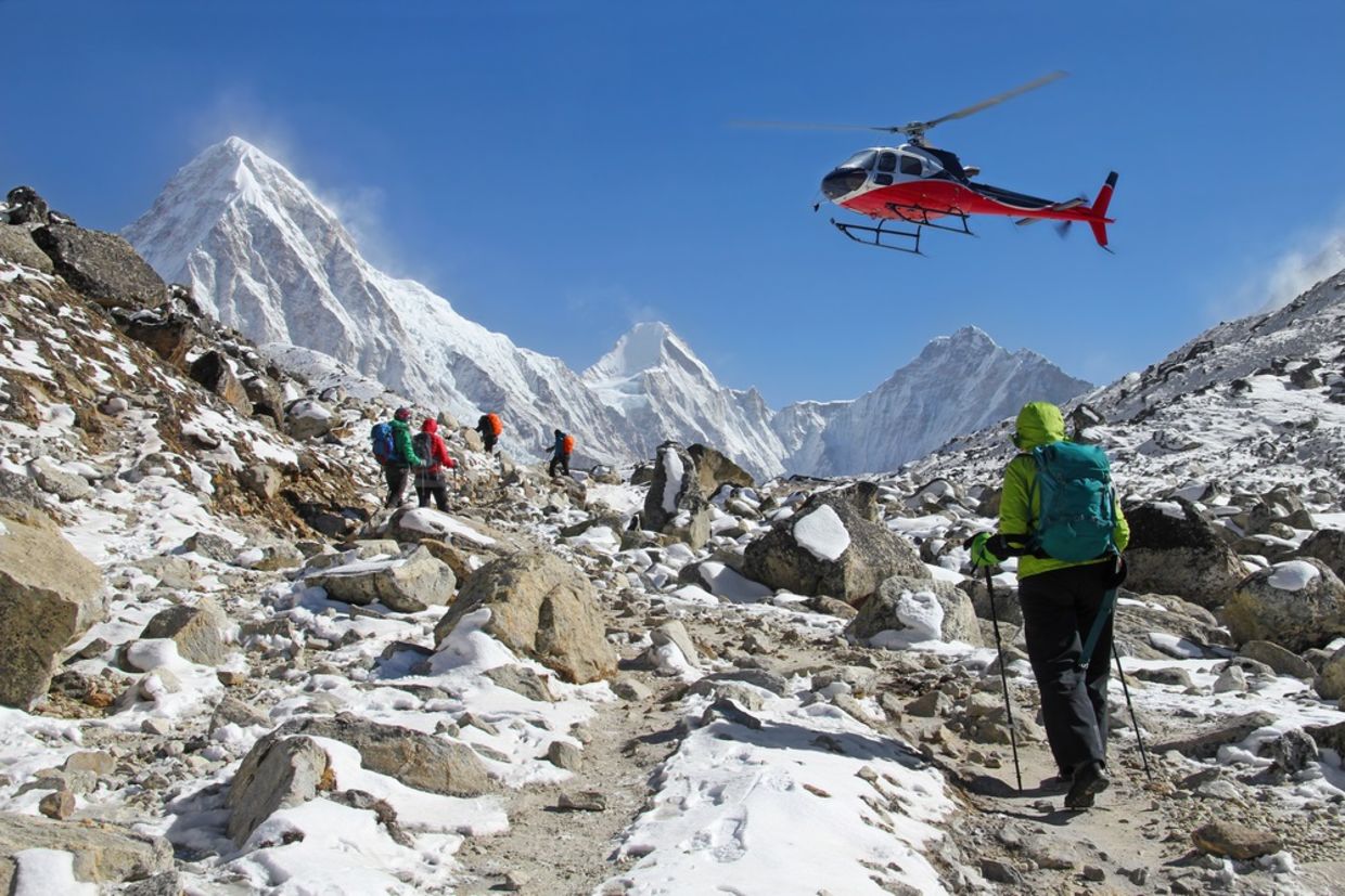 喜马拉雅山中的登山者，在山峰上，林格特伦，波莫里和昆布斯景色。救援直升机在尼泊尔行动