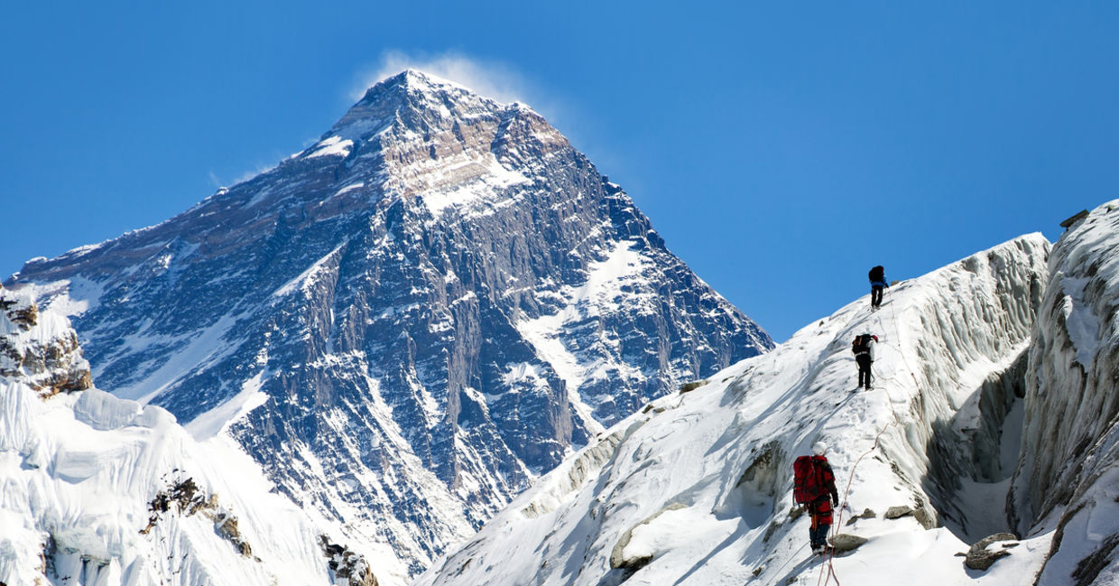 一群登山者在前往珠穆朗玛峰大本营的途中，从高角山谷俯瞰珠穆朗玛峰