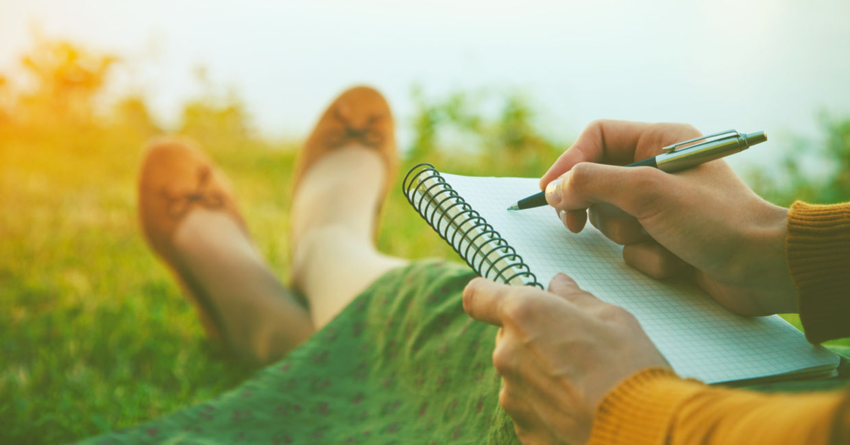 一个女人坐在大自然里写日记。