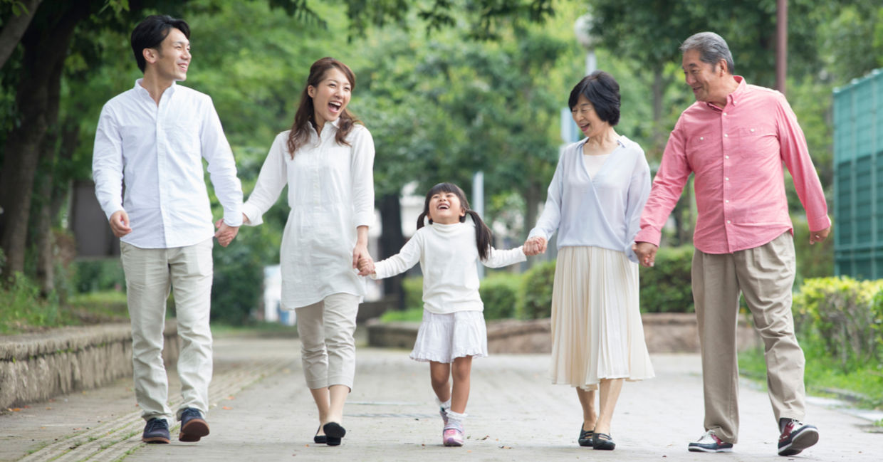 一个日本家庭保持联系，享受在公园散步。