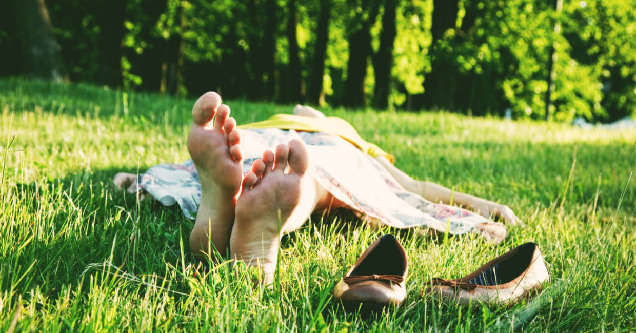 光着脚睡在草地上的女人。