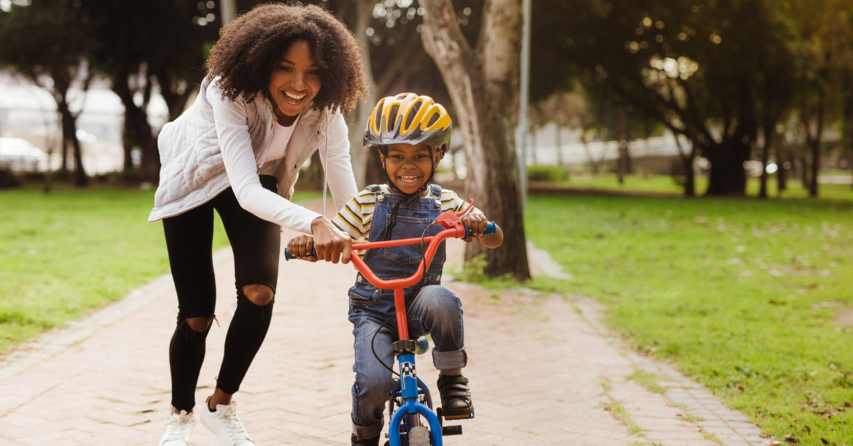 一位母亲教她的孩子如何骑自行车。
