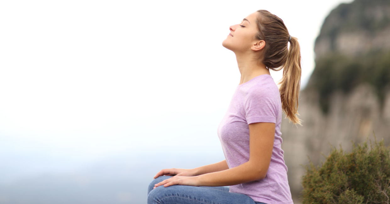 当她在外面练习正念的冥想时，一个女人专注于呼吸。