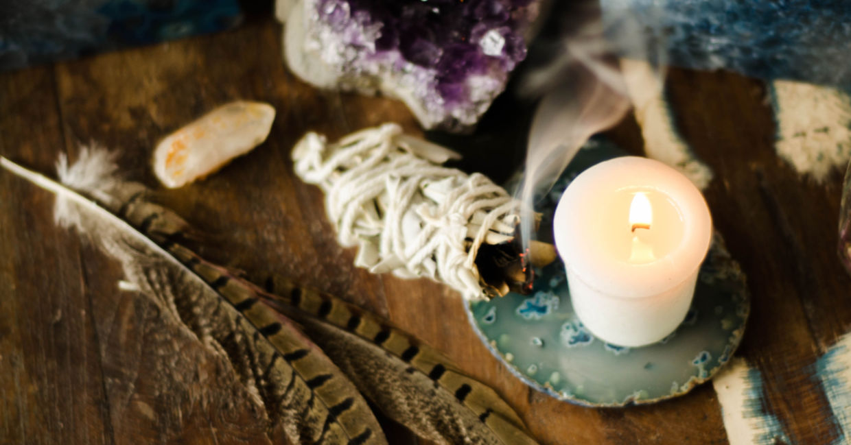 鼠尾草污迹棒，紫水晶，羽毛和一条蜡烛创造了一个神圣的冥想空间。
