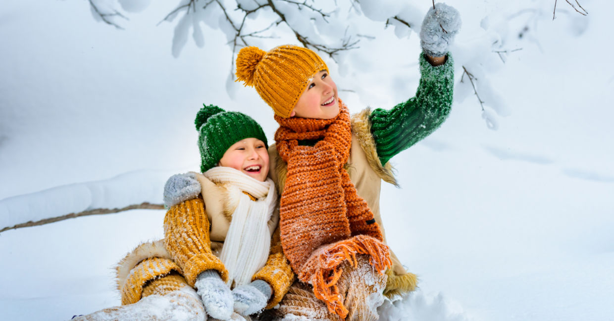 两个年轻女孩愉快地在雪中戏剧。