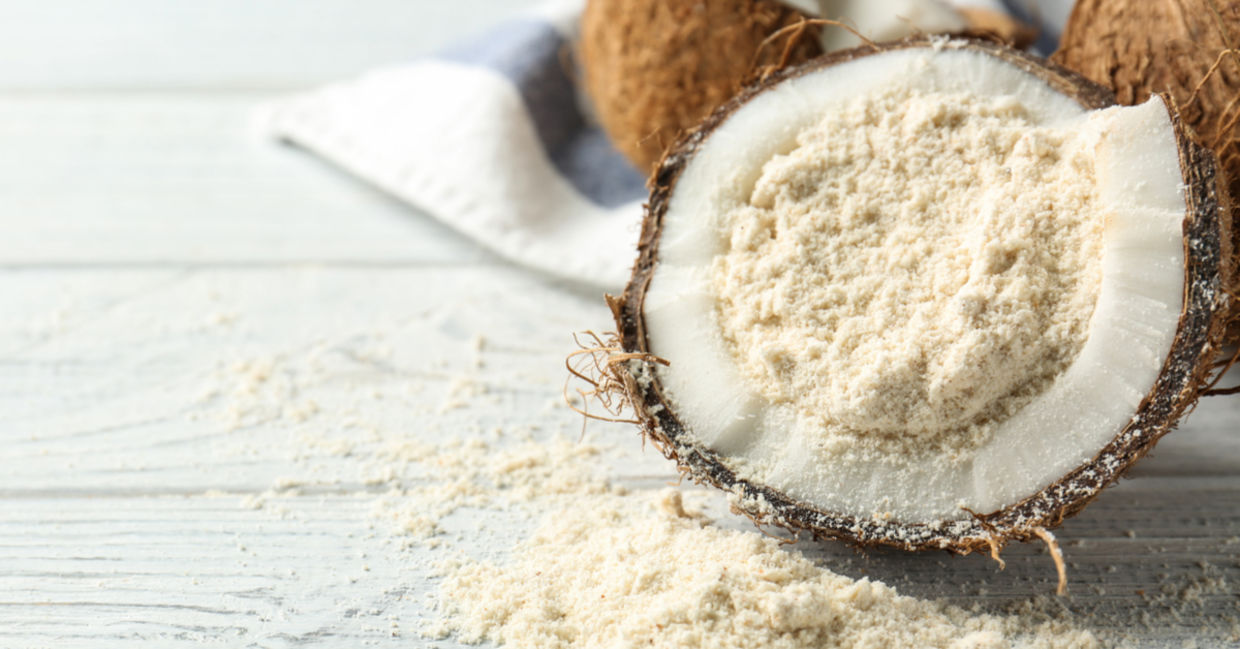 健康的无麸质椰子粉放在椰子壳中。