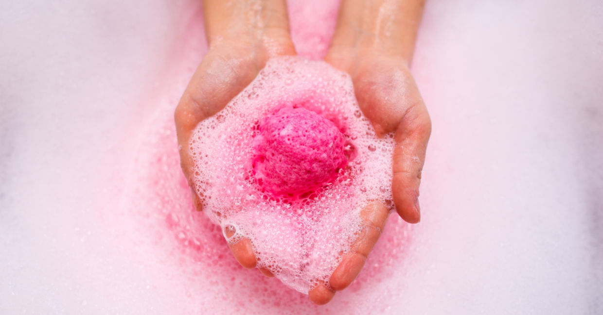一个粉红色的淋浴蒸笼溶解在一个女人的手中。