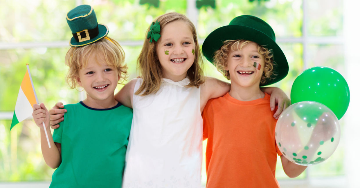 孩子们戴着妖精帽子挥舞着爱尔兰国旗，庆祝圣帕特里克节。