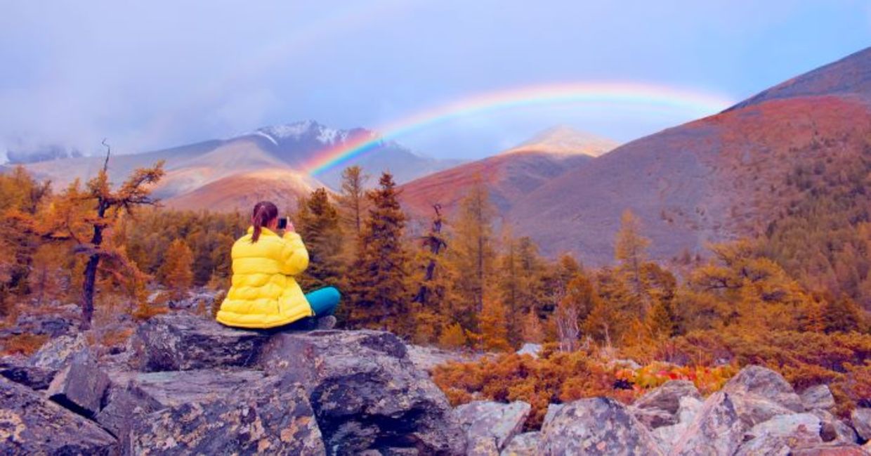 在坐在自然中坐在欣赏彩虹时寻找勇气。