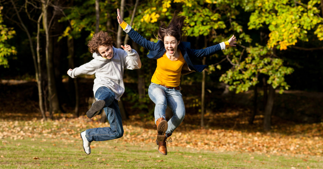 女孩和男孩跳跃并享受户外活动。