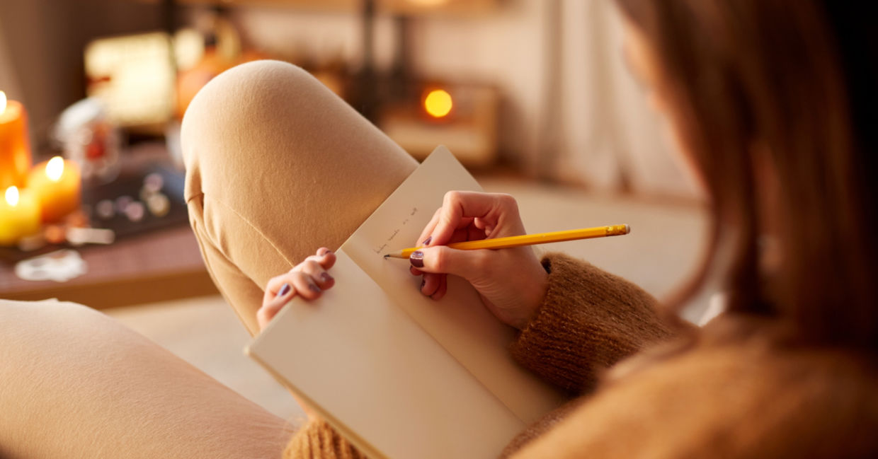 女人在日记中写作时，在她舒适的家中放松身心。