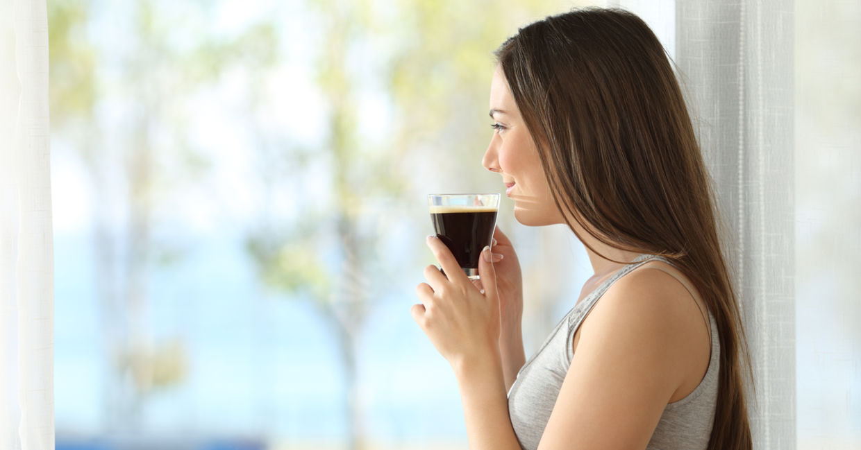 一个沉思的女人喝咖啡。